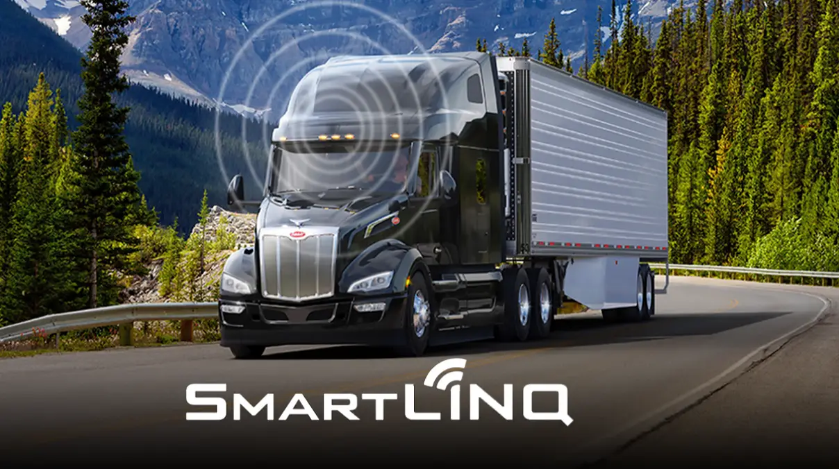 Black Peterbilt truck drives on highway with signal graphic displaying and SmartLINQ logo