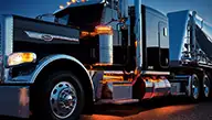 Peterbilt Model 389X at night with amber LED lights highlighting its masculine stance - Thumbnail