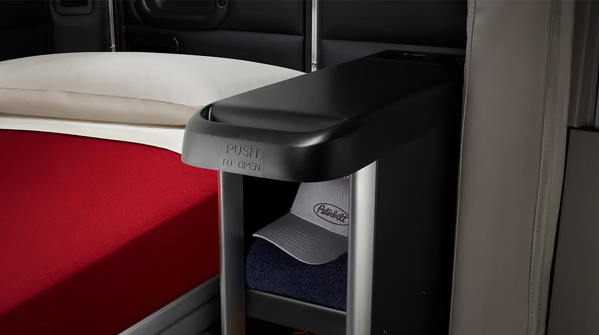 Peterbilt Model 589 On-Highway Interior Image of Sleeping Space with Shelf and Peterbilt Hat - Thumbnail
